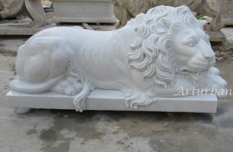 Lying lion statue in front of house