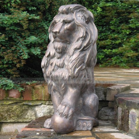 lion statue with paw on ball