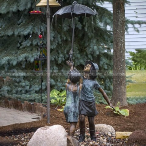 boy and girl under umbrella statue