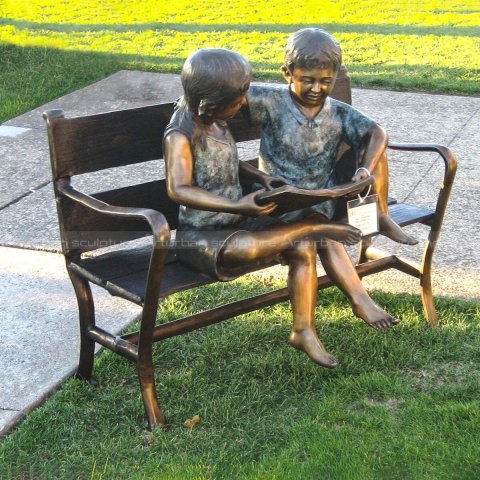 boy and girl reading book garden statue