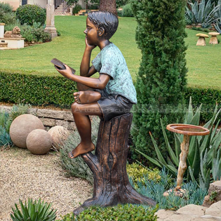 boy reading garden statue