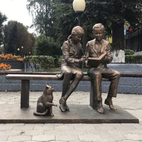 boy and girl reading on bench sculpture