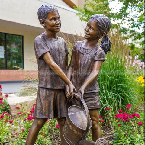 boy and girl watering flower sculpture