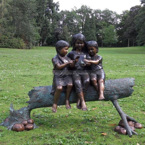 three kids on a log sculpture
